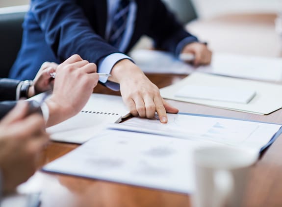 business person pointing at papers in a meeting