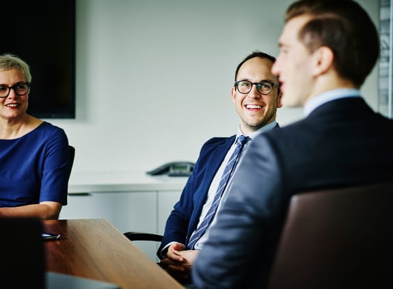 Laughing businesspeople in discussion during meeting in office conference room