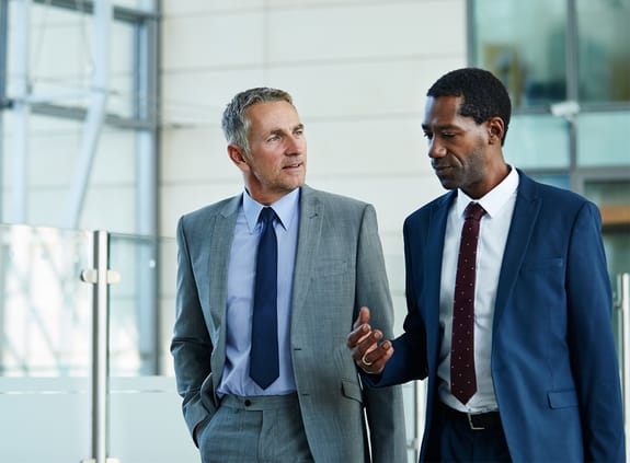two businessmen chatting in office lobby