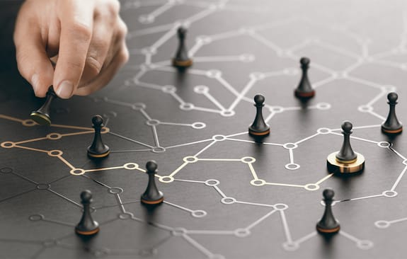 Hand moving pawn on a conceptual maze