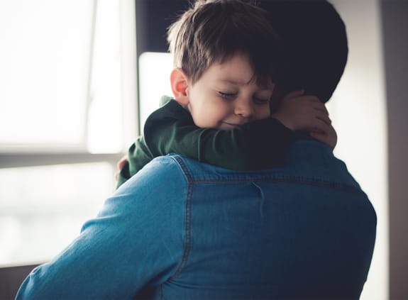 young boy hugging his father