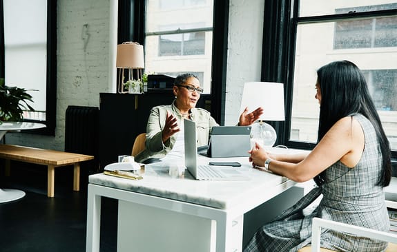 Business women chatting across a desk