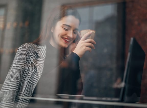 young woman on a coffee break, using laptop