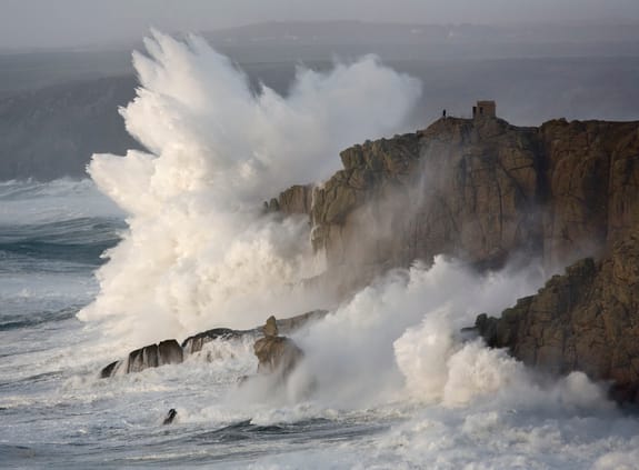 Waves crash against steep cliffs