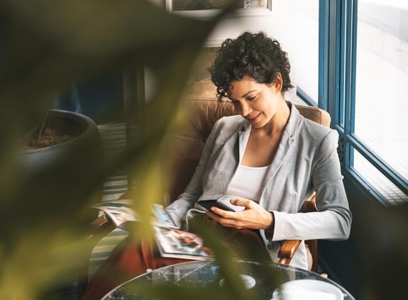 Woman sitting on a chair looking at her phone