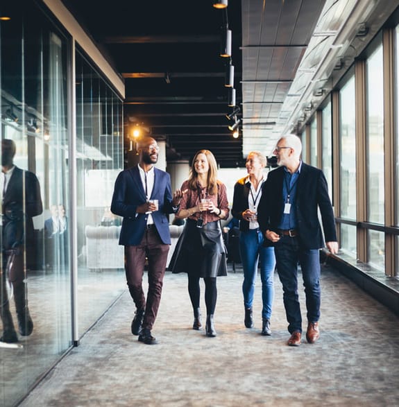 The business advisory team walk down a corridor between meetings