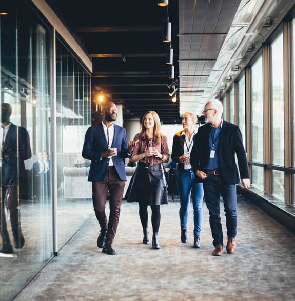 A group of people in conversation at the office