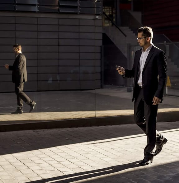 businessman walking in the street with reflection in glass