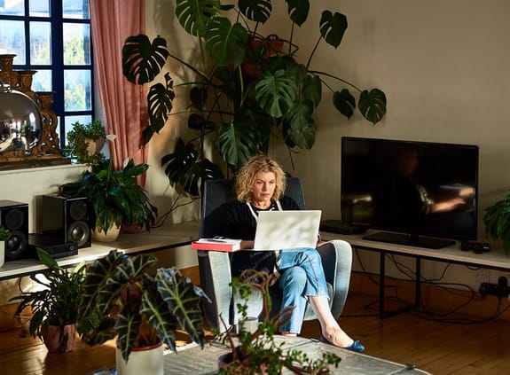 Woman sitting on a comfy chair working on her laptop