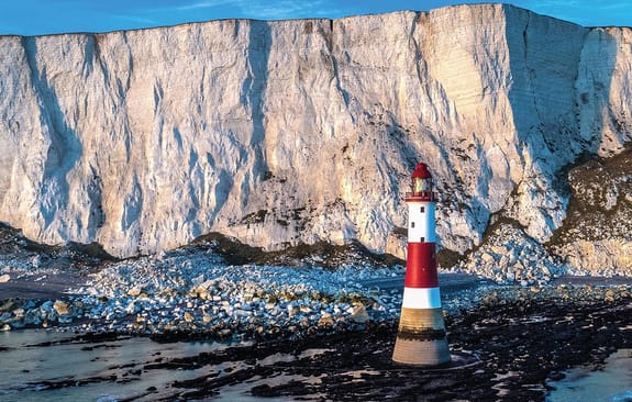 Red and white stripy lighthouse in front of chalk cliffs
