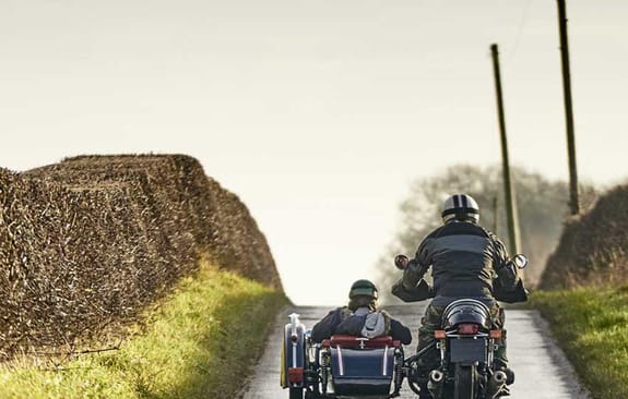 Motorcycle with sidecar driving through country roads