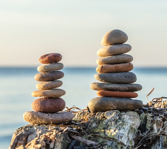 Stones stacked on top of a rock by the beach
