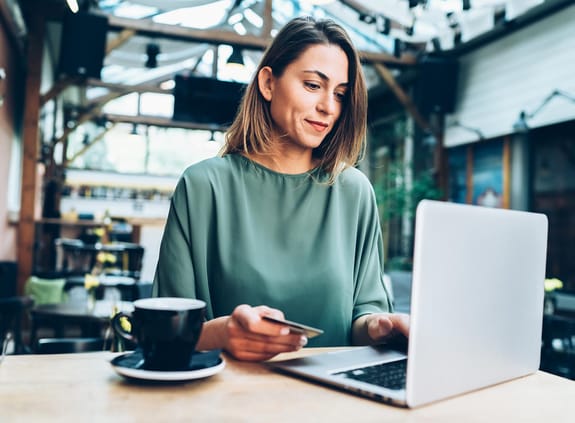 Woman working at a computer in a cafe