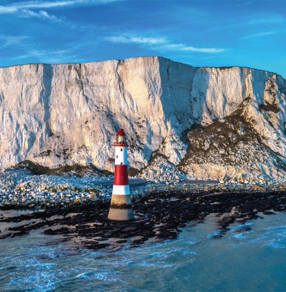 lighthouse with cliff face behind