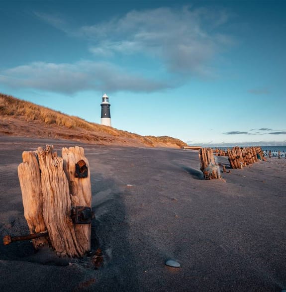A beach with lighthouse in the background