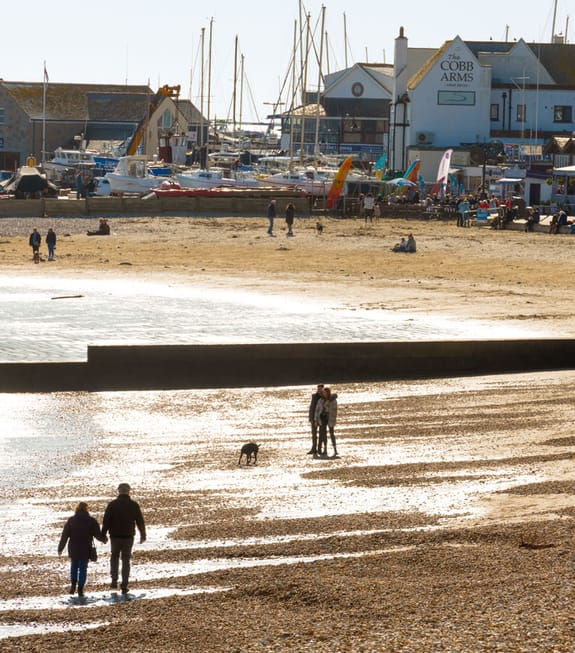 Couples strolling a pebble beach