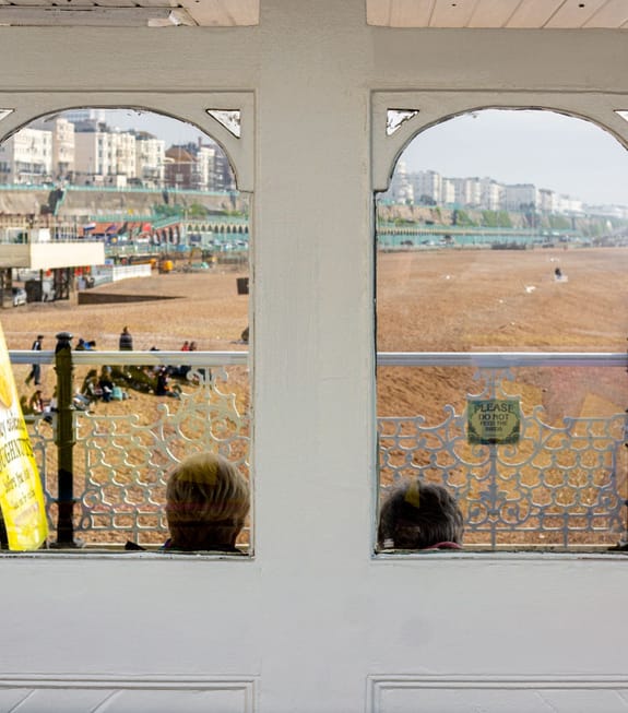 Elderly couple look out over Brighton beach from the pier