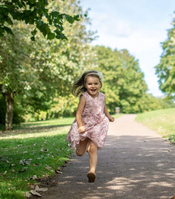 Young girl running down a path towards the camera