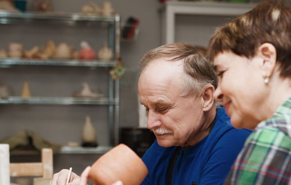 Middle-aged couple paint pottery together