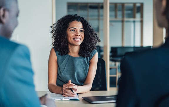 female chatting with colleagues in a meeting room