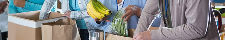 Volunteers packing food into bags at a food bank
