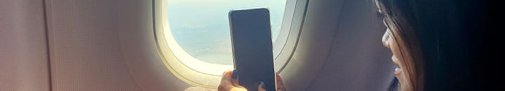 Female taking a photo through airplane window