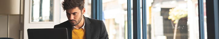 Male professional preparing LinkedIn profile sitting in cafe