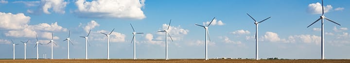 Row of wind turbines against a blue sky