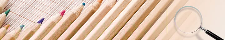 Row of coloured pencils on graph paper