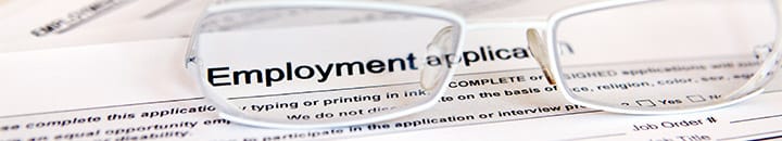 Employment application form with glasses sitting on top