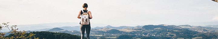 Female standing on top of cliff looking over edge