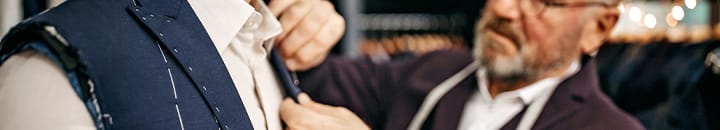 tailor fitting a male with a new suit