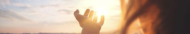 Woman with hand towards the sun