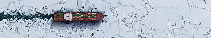 Cargo ship breaking through ice