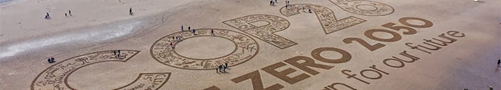 COP26 Net Zero 2050 Make a plan for our future written in the sand on a beach