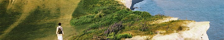 person walking on a cliff top