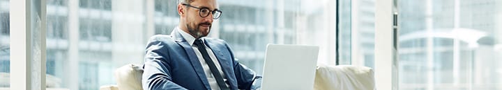 Businessman checking laptop while waiting in airport lounge
