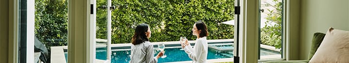 Female friends enjoying a glass of wine outside on the garden terrace
