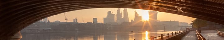 view of london city from under a bridge across the thames