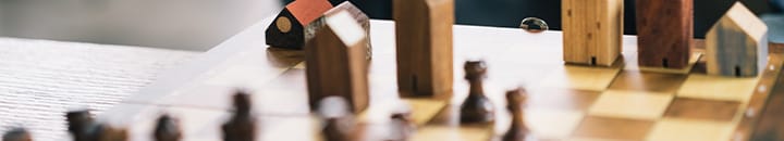 Dad teaching son to play chess with set showing houses