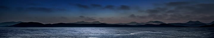 Full moon casting light over the ocean at night