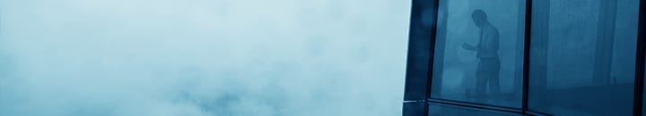 Man looking out of winow into heavy fog