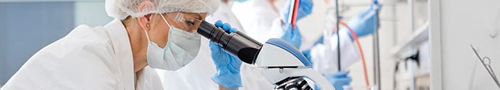 scientist looking through a microscope