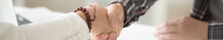 Businessman handshaking businesswoman after agreeing a deal
