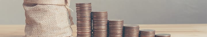 Stacks of pennies and saved pennies in a sack