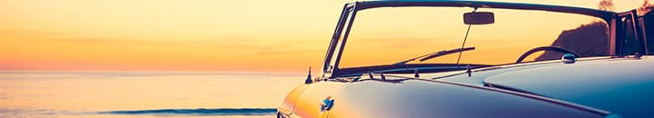 Retirement sports car sitting on beach at sunset