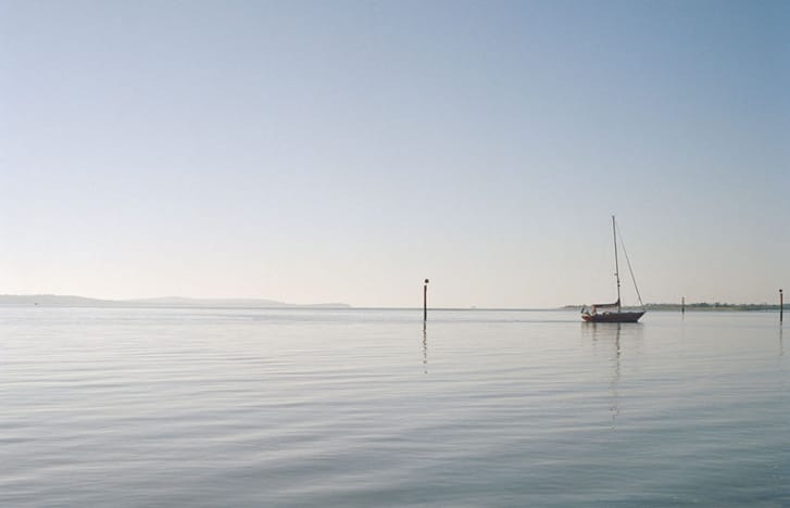 Lone sailboat on calm waters
