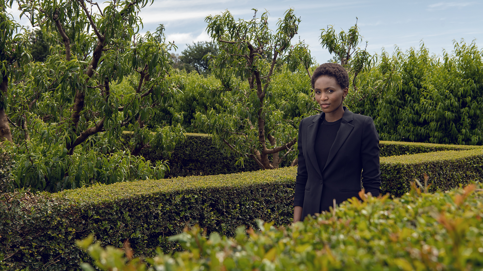 Woman walking through a hedge maze