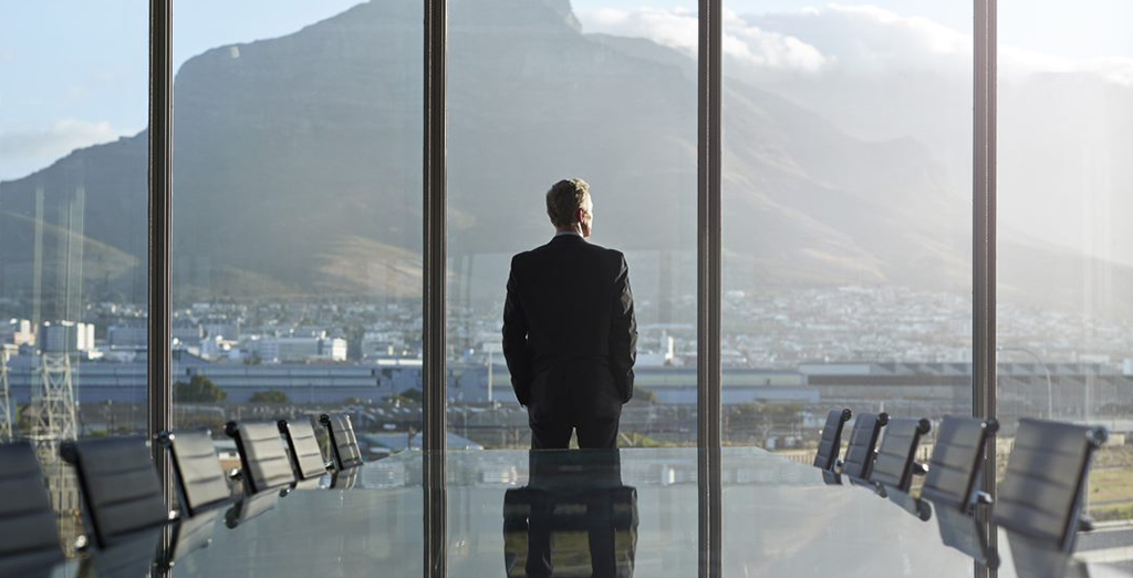 Businessman staring outside of a meeting room window