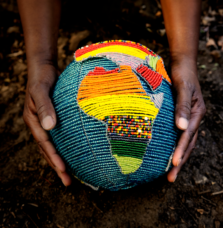 Hands holding a world globe beaded in africa